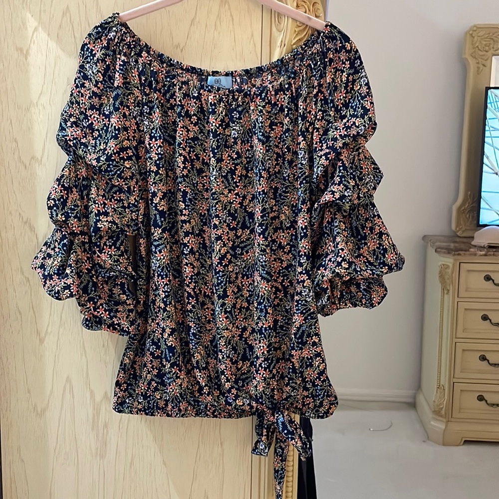 CeCe floral top. Dark blue background. Pinkish/blue/lavender flowers